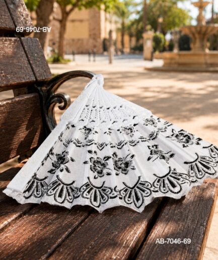 Abanico de mano con detalles de encaje y estampado floral en color negro sobre fondo blanco, con estructura perforada AB7046