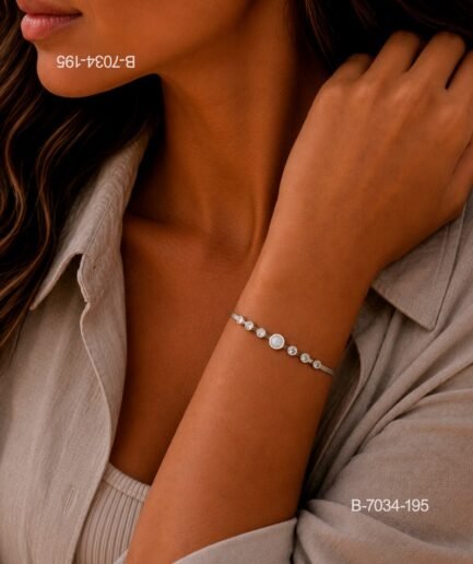 Pulsera de diseño elegante en color plateado o metalizado, compuesta por una cadena rígida o semi-rígida decorada con una secuencia de pequeños cristales y una piedra o perla central B7034