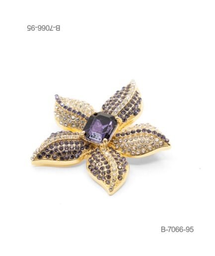 Prendedor de diseño elegante en color dorado, con forma de flor pavimentada de pedrería brillante en tonos claros y oscuros, coronada por un gran cristal central de corte rectangular en color violeta B7066