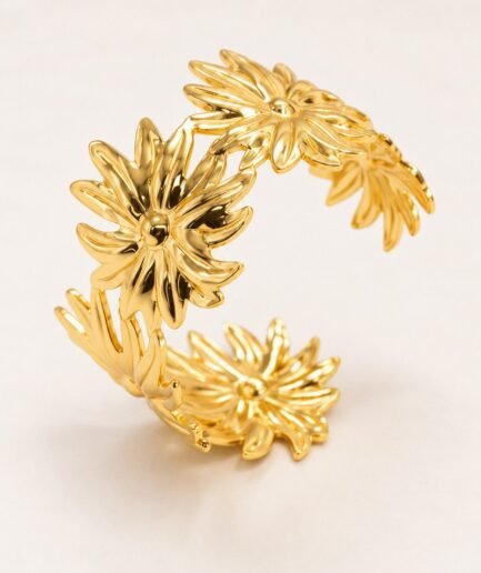 Pulsera rígida abierta con diseño texturizado de margaritas y acabado dorado brillante P0755